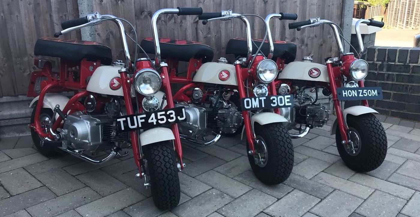 Three restored red Honda Monkey bikes